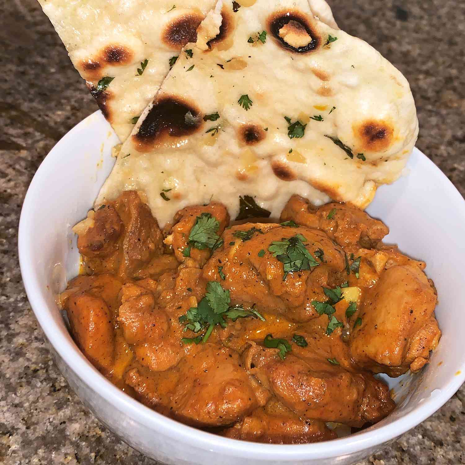 Enjoying butter garlic naan with a steaming hot curry, a perfect culinary combination
