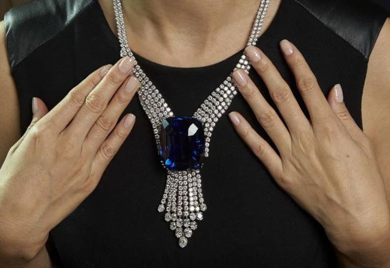 Detail of the Blue Belle of Asia sapphire necklace, emphasizing the unique blue-violet hue and its luxurious diamond embellishments