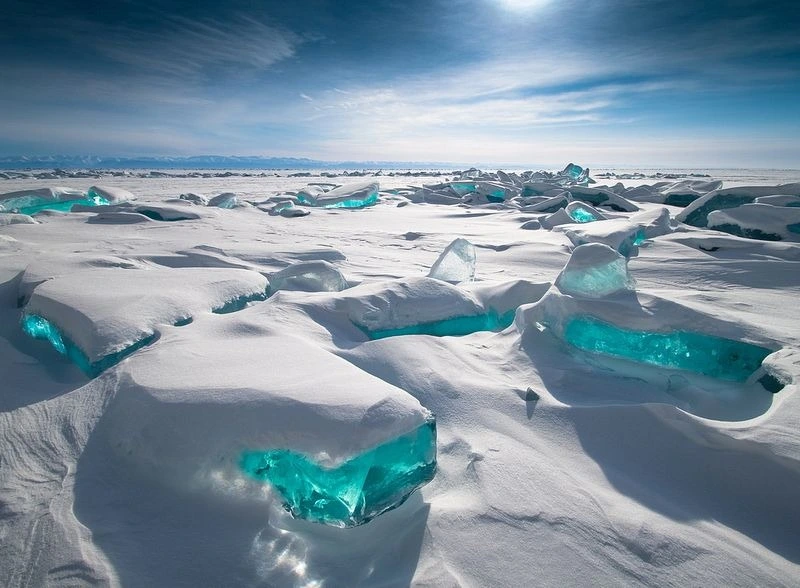 Crystal-clear waters of Lake Baikal, the world's deepest freshwater lake, surrounded by snow-capped mountains.