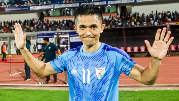 Sunil Chhetri proudly holding a trophy after a victorious match with the Indian national team.